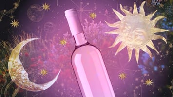 A wine bottle is placed upon a background of flowers and stars with a moon to the left and a sun to the right